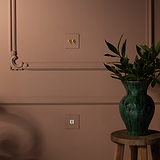 Interruttore a Levetta Singolo 2x in Pitturabile Ottone Antico su una parete rosa, a complemento di un arredamento vintage.