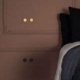 Interruttore e dimmer doppio 2x Ottone Antico Pitturabile montato su parete con modanature decorative.