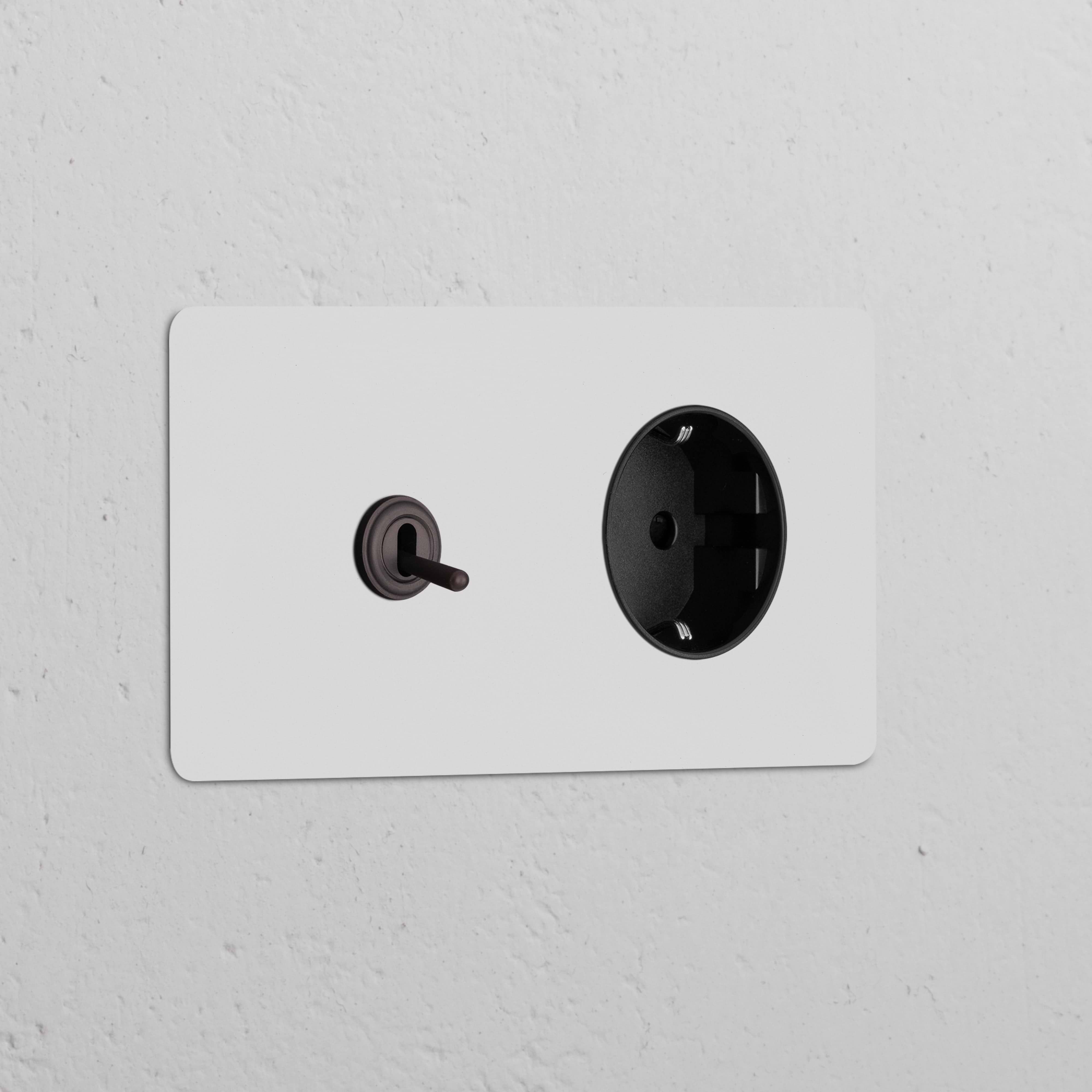 Módulo duplo redondo com interruptor articulado e tomada Schuko Tipo F, bronze pintável em preto.
