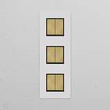 Triple 6x Vertical Rocker Switch in Paintable Antique Brass Black finish on a white textured wall.
