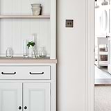 Bronze Sycamore Furniture Handle on Cream Cupboard Furniture Next to Light Switch