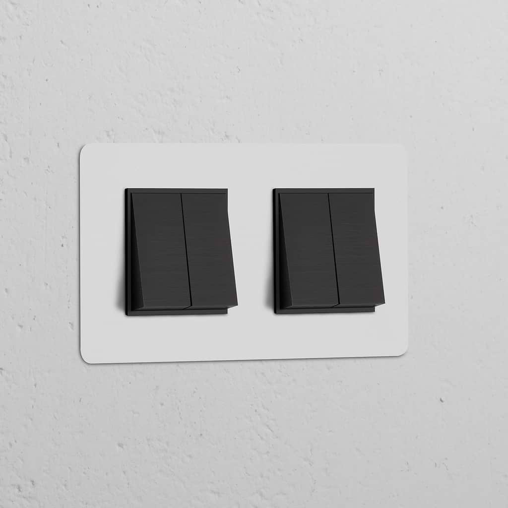 Double 4x Rocker Switch with Paintable Bronze Black finish on a white wall, designed for switches and dimmers.