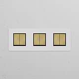Triple 6x Rocker Switch Paintable Antique Brass Black mounted on a white wall; elegant and sophisticated design.