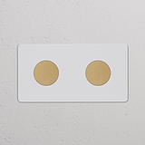 Double 2x Multiway Dimmer Switch in paintable antique brass with two round dimmer knobs, wall-mounted.