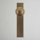 Poplar Long Plate Sprung Door Knob Antique Brass Finish on White Background Front Facing