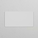 Double Blank Plate – Paintable: EU paintable switch plate on a textured white background.