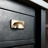 Antique Brass Elm Cup Handle on Black Furniture