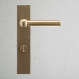 Harper Long Plate Sprung Door Handle & Thumbturn Antique Brass Finish on White Background Front Facing