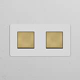 Double 2x rocker switch with antique brass white finish, for Double Switches & Dimmers, on a textured wall.
