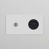 Double toggle switch with Swiss Type J power module in polished nickel on a white wall.
