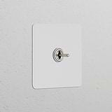 Single Toggle Switch (Cent) Paintable Polished Nickel on a white textured wall, part of Single Switches & Dimmers.