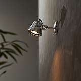 Cambridge Wall Floodlight in polished nickel mounted outdoors on a wall, casting downward light.