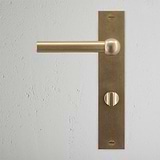 Harper Long Plate Sprung Door Handle & Thumbturn Antique Brass Finish on White Background right Facing Front View