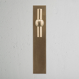 Harper T-Bar Long Plate Sprung Door Handle Antique Brass Finish on White Background Front Facing