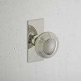 Poplar Short Plate Sprung Door Knob Polished Nickel Finish on White Background