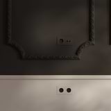 Double 2x Toggle Switch + Schuko Type F Power Module Round in Paintable Bronze Black on a textured wall.