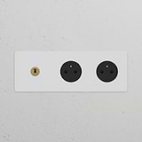 Triple Toggle Switch with 2 Type E Power Modules in Paintable Antique Brass Black Finish on Textured Wall.
