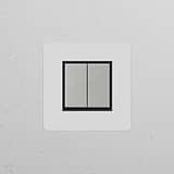 Single 2x rocker switch in polished nickel black, suitable for single switches & dimmers on a textured white wall.