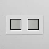 Double rocker switch in polished nickel on a textured white wall, part of the Double Switches & Dimmers range.
