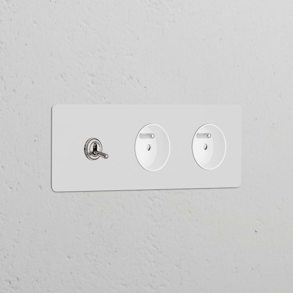 Triple toggle switch panel with 2 Type E sockets, polished nickel white, paintable for decor integration.