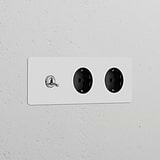 Triple toggle switch with 2x Schuko Type F power modules in polished nickel, suitable for painting, on black background.