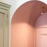 Antique brass Baylis small single spotlight (35mm) illuminating a pink interior archway.