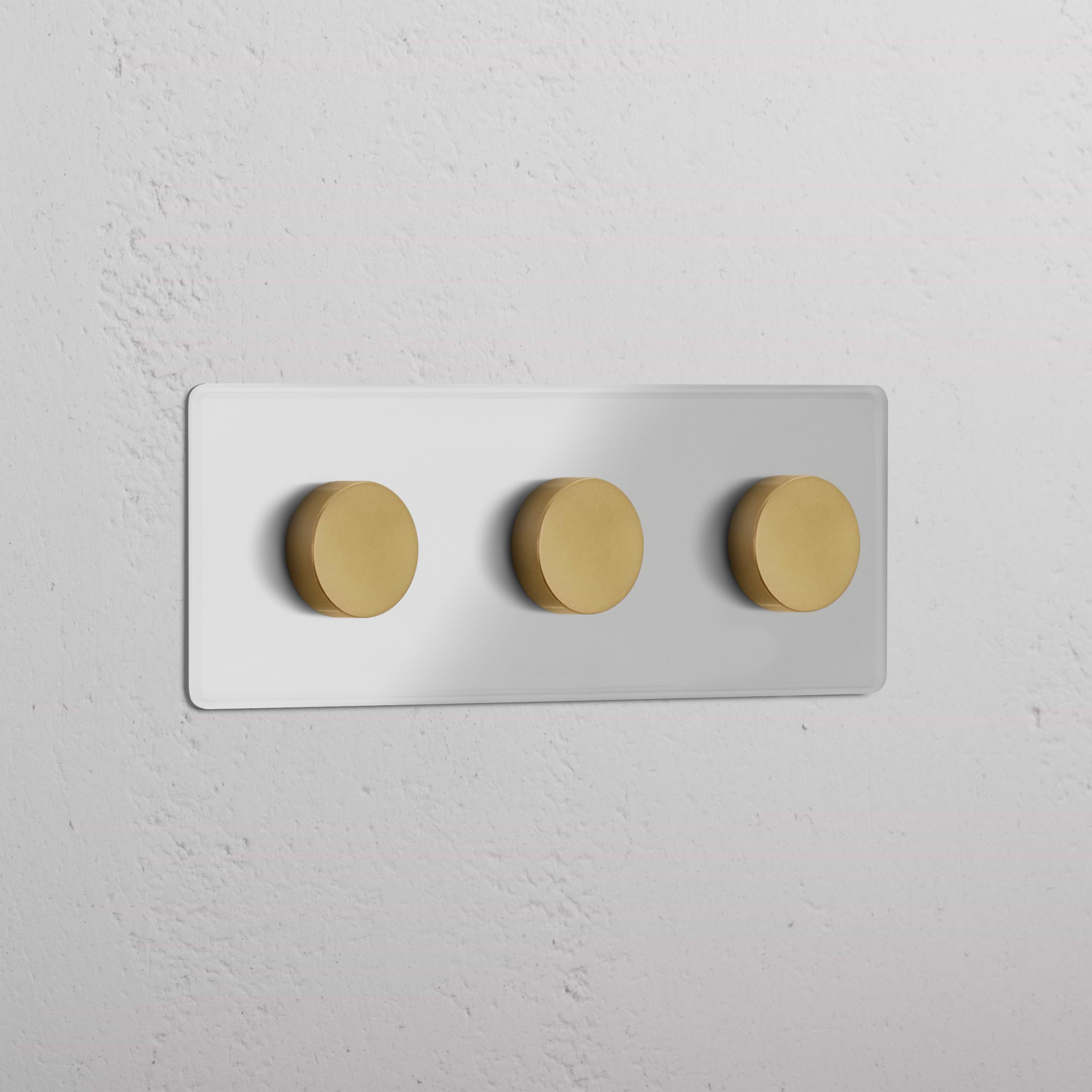 Clear antique brass triple 3x multiway dimmer switch with three round knobs on a white wall plate.