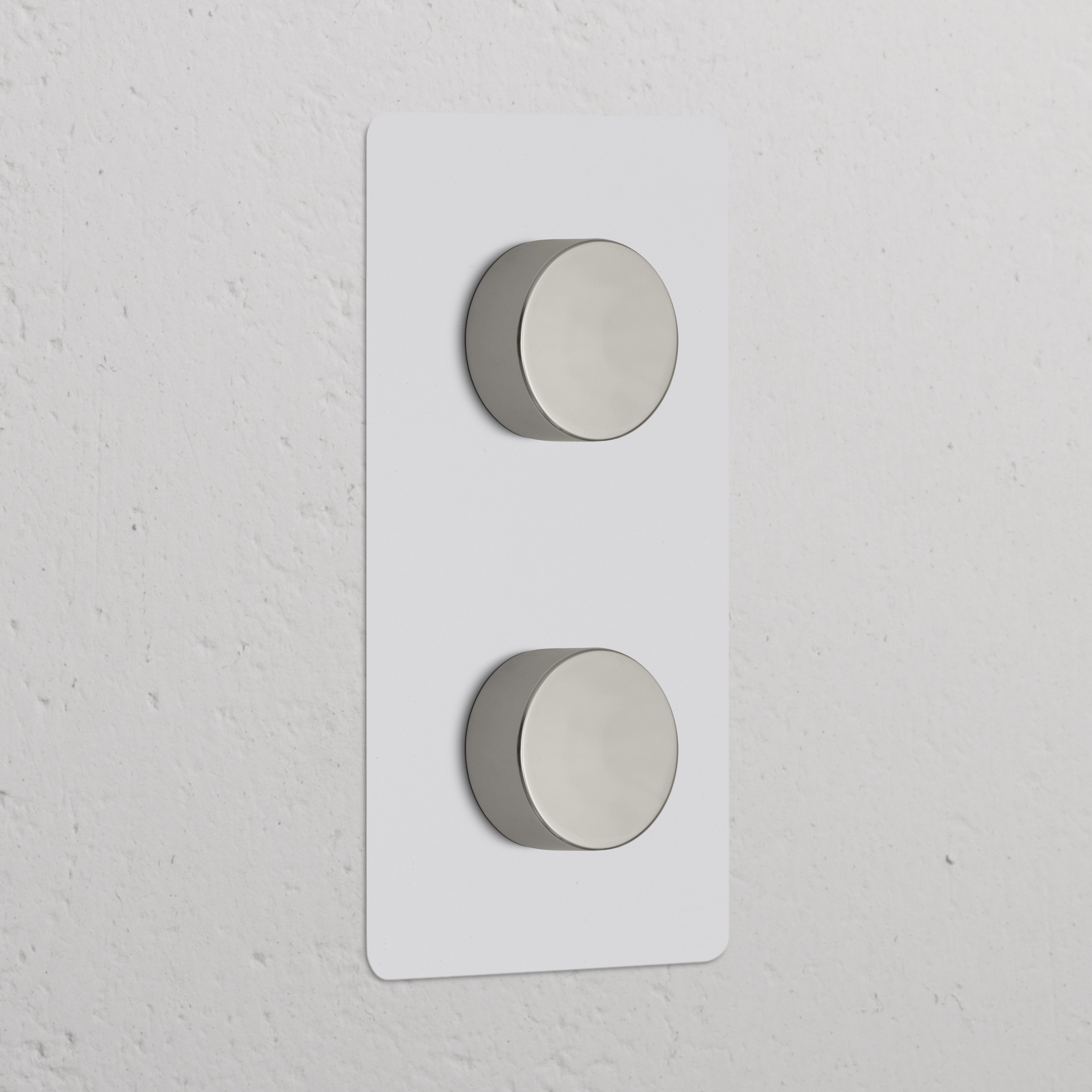 Double 2x Vertical Dimmer Switch in paintable polished nickel with two silver knobs on a sleek white wall plate.