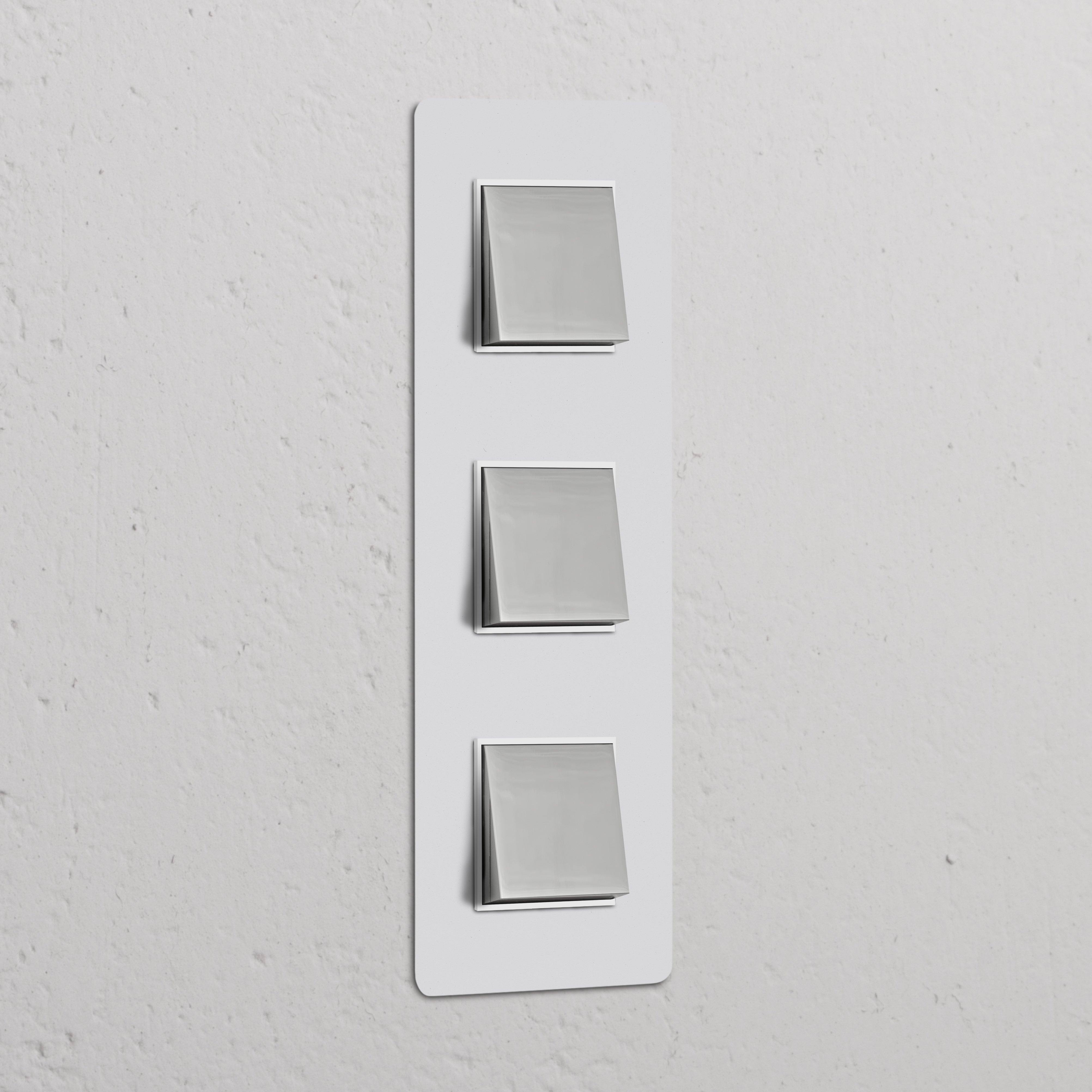 Triple 3x vertical rocker switches in polished nickel white on a textured wall, offering style and functionality.