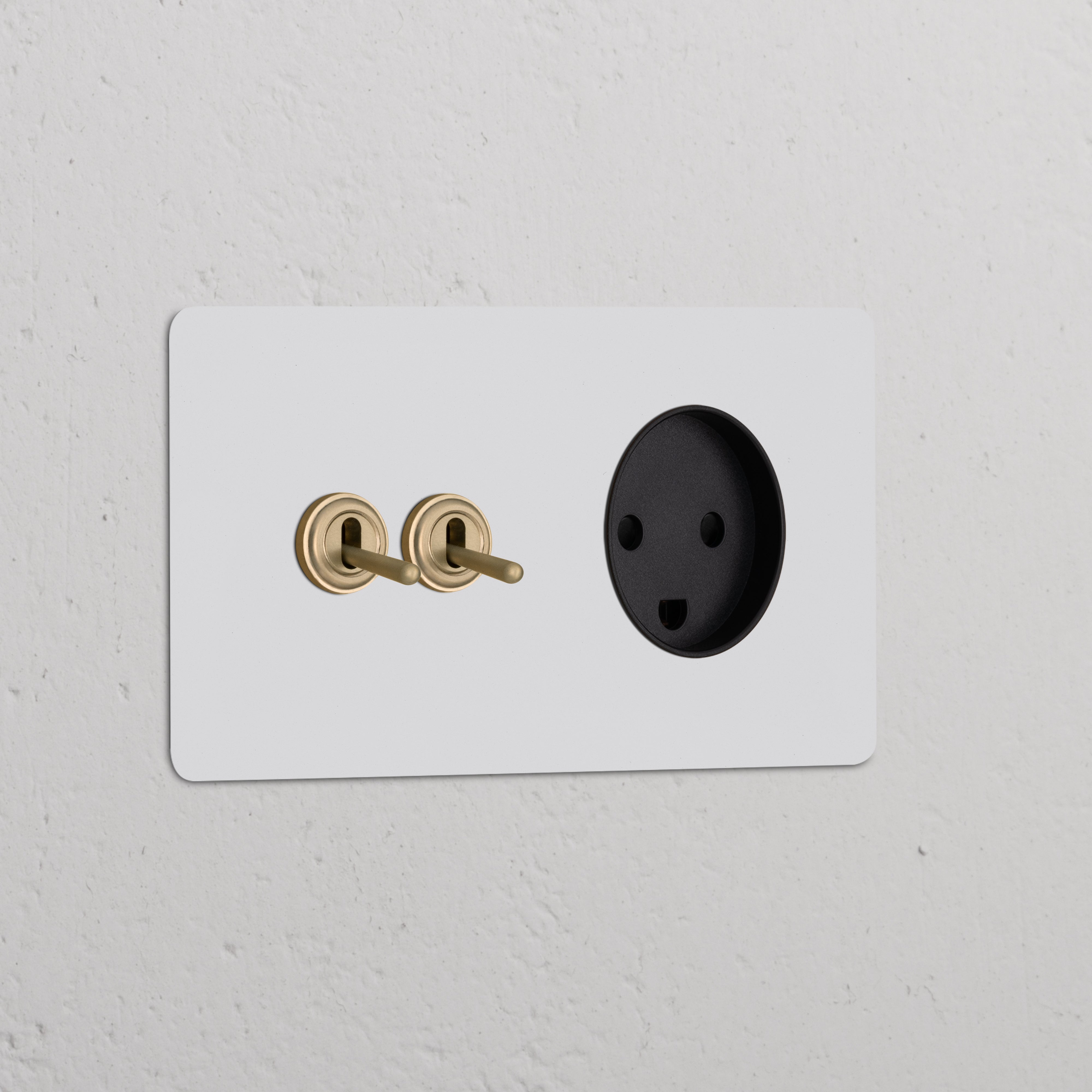 Double 2x toggle switch and Danish Type K power module in antique brass black on a white wall.