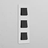 Triple 3x Vertical Rocker Switch with Paintable Bronze Black finish for Triple Switches & Dimmers on a white panel.