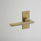 Clayton Short Plate Fixed Door Handle Antique Brass Finish on White Background at an Angle