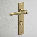 Harper Long Plate Sprung Door Handle & Thumbturn Antique Brass Finish on White Background at an Angle