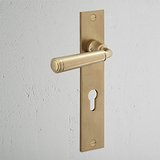 Digby Long Plate Sprung Door Handle & Euro Lock Antique Brass Finish on White Background at an Angle