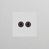 Paintable bronze single 2x toggle switch on a wall, suitable for switches & dimmers.
