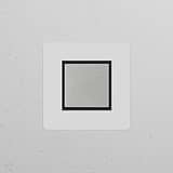 Single Rocker Switch (Cent) in paintable polished nickel and black, mounted on a textured white wall.