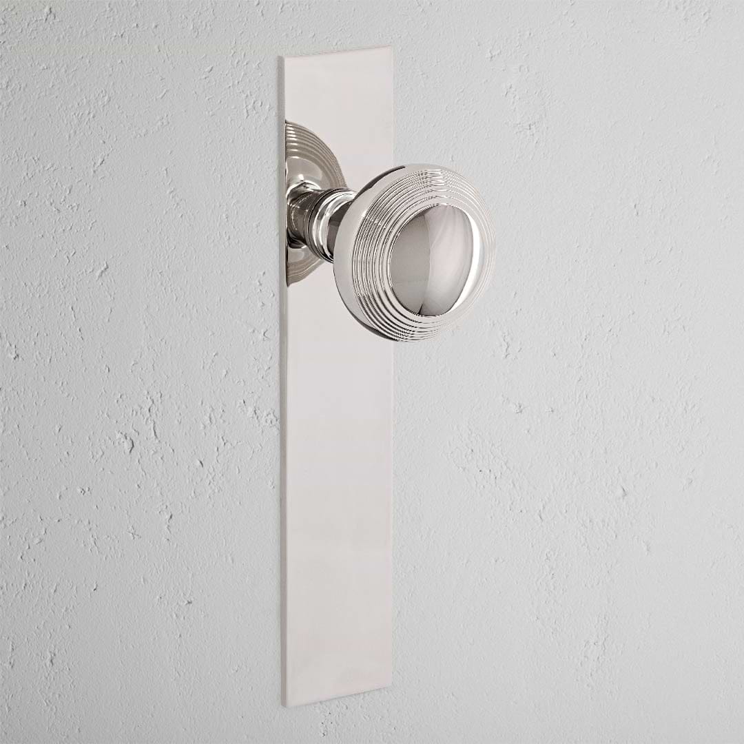Poplar Long Plate Sprung Door Knob Polished Nickel Finish on White Background
