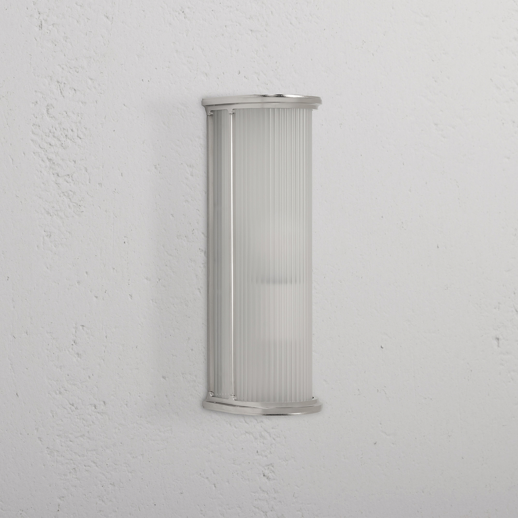 Medium wall light featuring fluted frosted glass and polished nickel trim, mounted on a white wall.