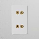 Double 4x Vertical Toggle Switch in paintable antique brass with an elegant finish on a white wall.
