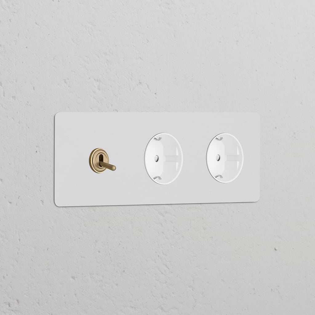 Triple toggle switch & 2x Schuko Type F sockets, paintable antique brass on white surface, Triple Sockets & Modules.