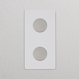 Double 2x Vertical Multiway Dimmer Switch in paintable polished nickel with two round knobs, shown on a wall.