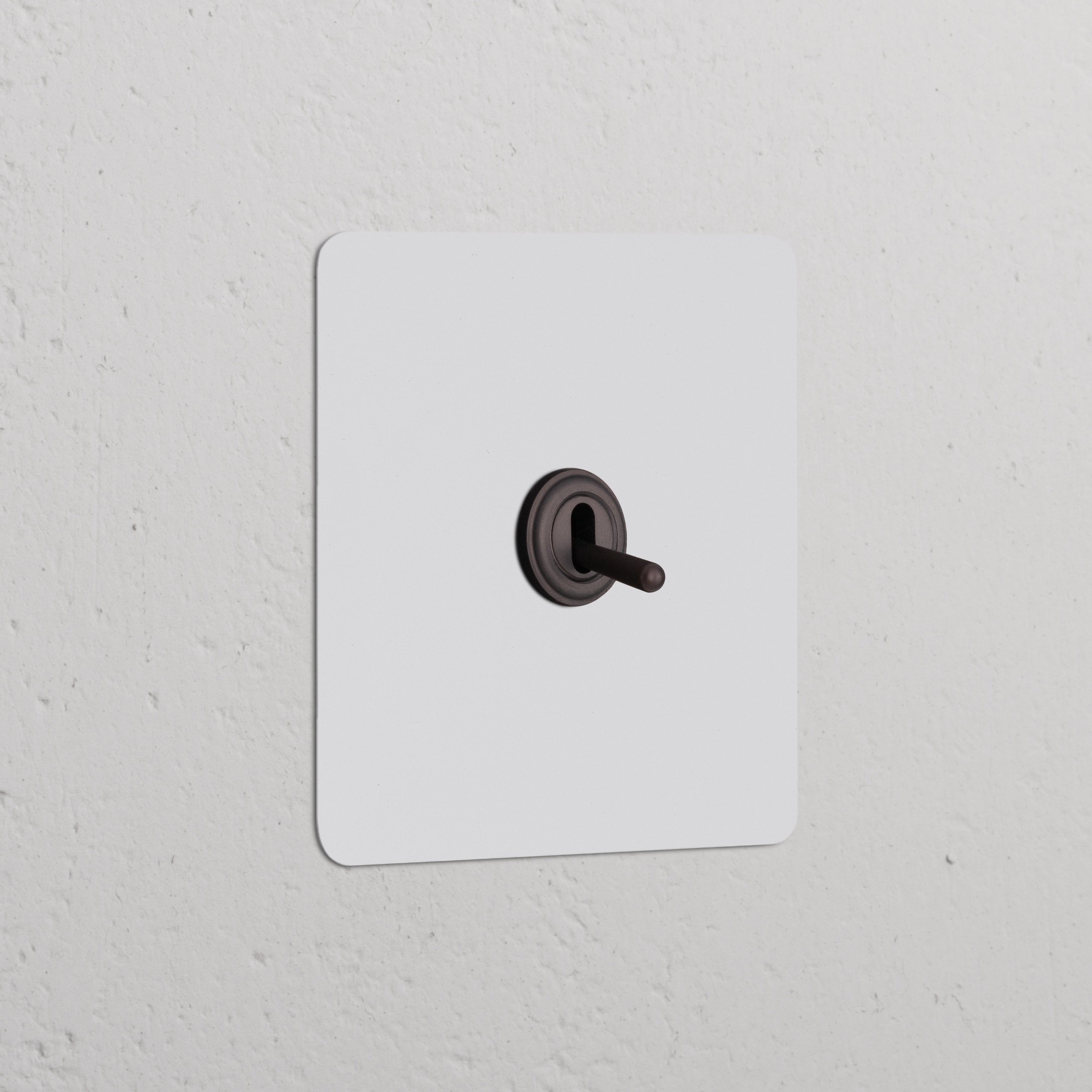 Single Toggle Switch in Paintable Bronze finish, part of the Single Switches & Dimmers collection, on a white wall.