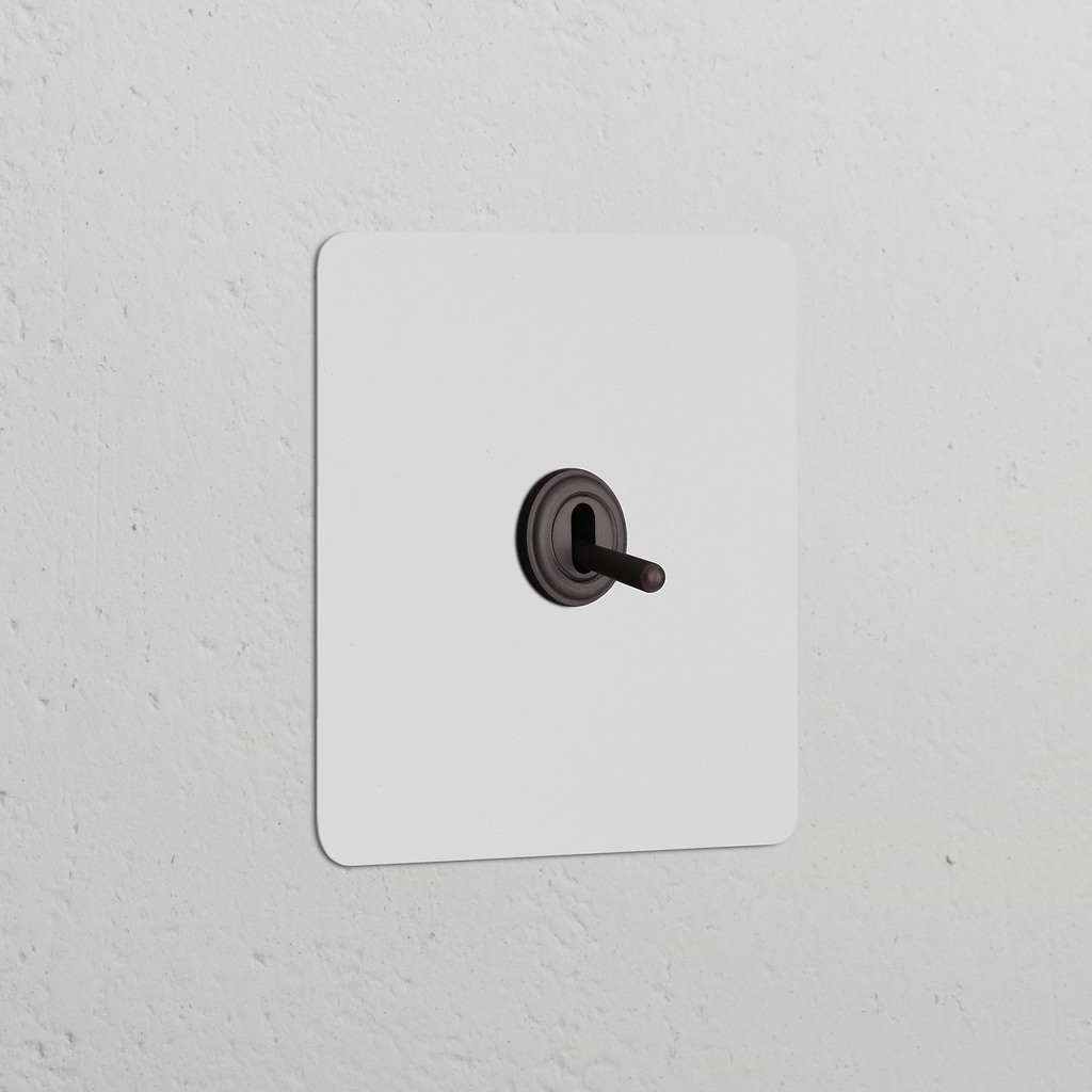 Single Toggle Switch in Paintable Bronze finish, part of the Single Switches & Dimmers collection, on a white wall.