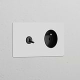 Double Toggle Switch and Type E Power Module Round in Paintable Bronze Black on a white textured wall.