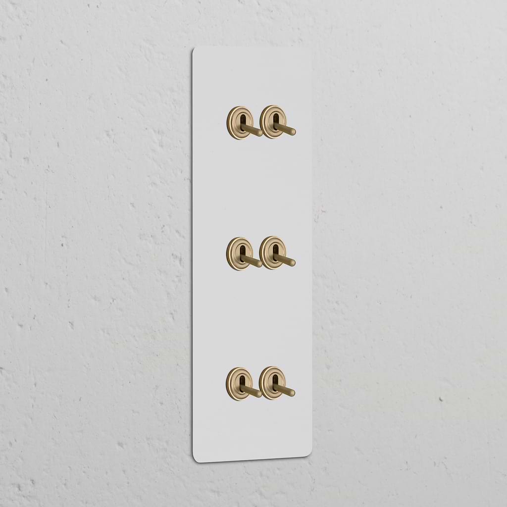 Triple 6x Vertical Toggle Switch Paintable Antique Brass on a white wall, combining style and function.