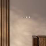 Triple toggle switch with 2 French Type E modules in polished nickel white on beige wall with wooden paneling.
