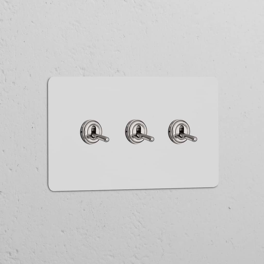 Polished nickel triple toggle switch on a paintable white panel, part of Double Switches & Dimmers collection.