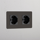 Bronze Black Double 2x Schuko/Bipasso Module wall socket, mounted on a white textured surface.