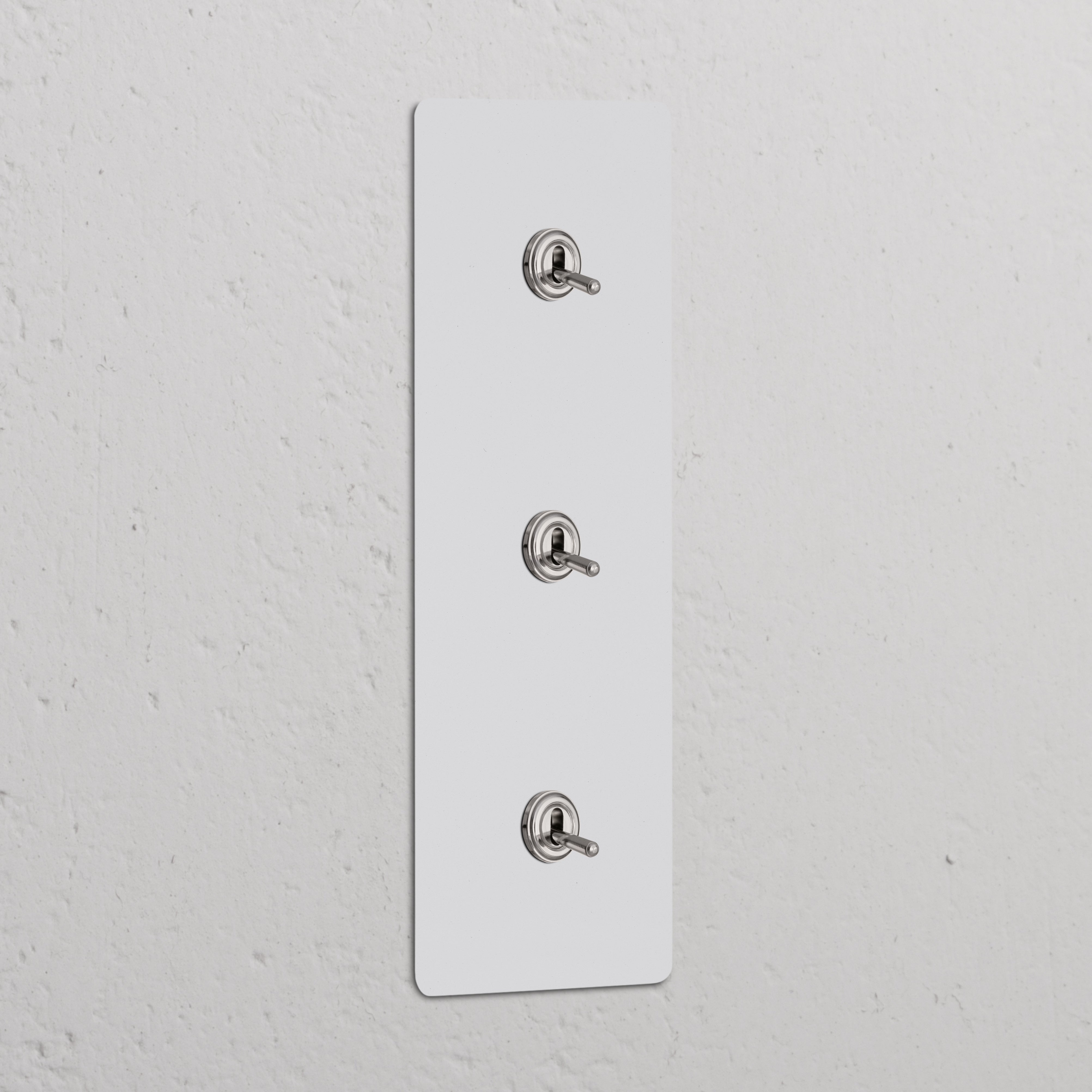 Triple 3x vertical toggle switches in polished nickel, paintable finish on switch panel for refined decor integration.