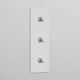 Triple 3x vertical toggle switches in polished nickel, paintable finish on switch panel for refined decor integration.